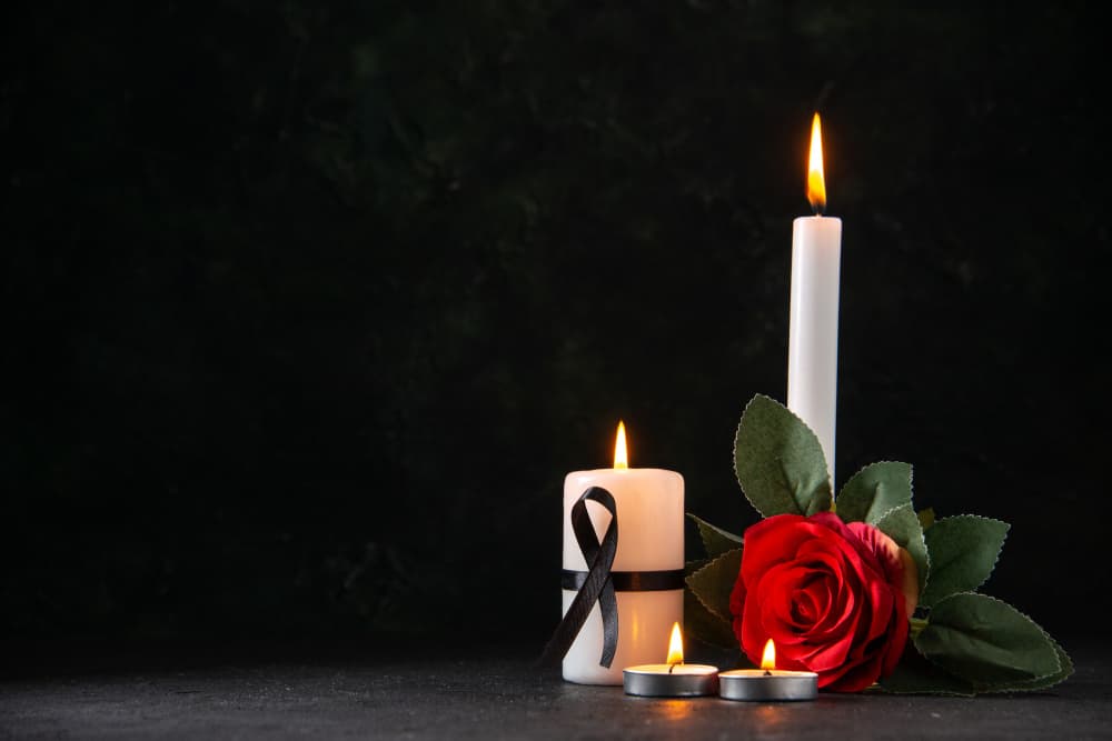 Memorial candles and a red rose
